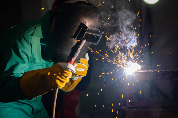 Metal welding steel works using electric arc welding machine to weld steel at factory. Metalwork manufacturing and construction maintenance service by manual skill labor concept.