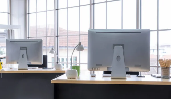 Desktop PC computers in small modern office or home office. Trendy workplace interior.