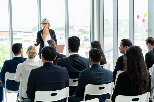 Встреча группы деловых людей на семинаре. Аудитория слушает инструктора на тренинге по обучению сотрудников. Форум сообщества офисных работников с экспертным докладчиком .