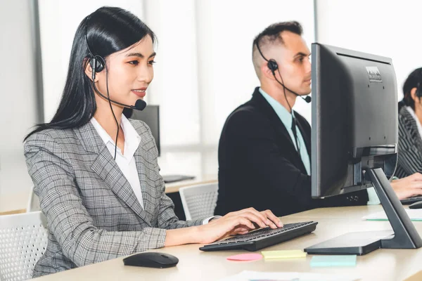 Ofiste çalışan kulaklık takan işadamları uzak müşteri ya da meslektaşlarını desteklemek için çalışıyorlar. Arama merkezi, tele pazarlama, müşteri destek acentesi telefon görüşmesinde hizmet sunar.