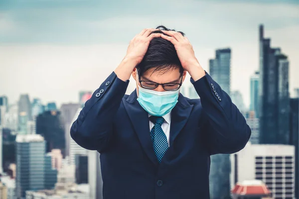 Unhappy lost business man with face mask protect from Coronavirus or Covid-19 suffers economic recession trouble. Concept of unemployment problem crisis caused by pandemic of Coronavirus Covid-19.