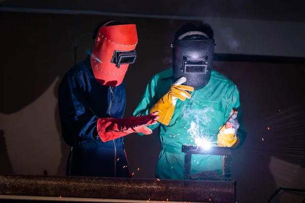 Metal welding steel works using electric arc welding machine to weld steel at factory. Metalwork manufacturing and construction maintenance service by manual skill labor concept.