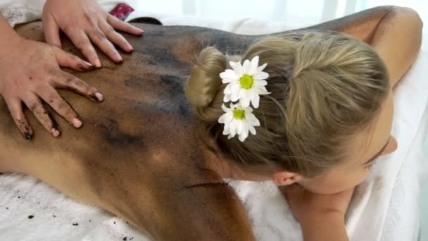 Χαλαρωμένη γυναίκα ξαπλωμένη στο κρεβάτι spa για μασάζ καθαρισμού σώματος χρησιμοποιώντας παραδοσιακό βότανο — Αρχείο Βίντεο