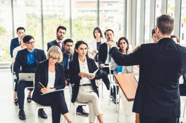 Bir grup iş adamı seminer konferansında toplanıyor. Seyirciler, çalışanların eğitim seanslarındaki eğitmenleri dinliyor. Uzman konuşmacı ile ofis çalışanları toplantısı .