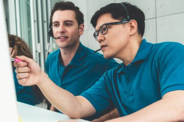 Ofiste çalışan kulaklık takan işadamları uzak müşteri ya da meslektaşlarını desteklemek için çalışıyorlar. Arama merkezi, tele pazarlama, müşteri destek acentesi telefon görüşmesinde hizmet sunar.