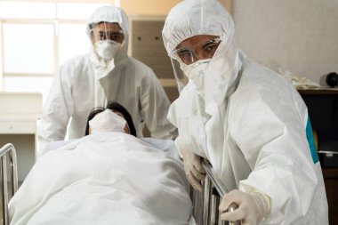 Acil servis doktoru ve doktor hastayı hastanedeki acil servise götürüyor. Doktor koronavirüs ve covid 19 koruma ve karantina kavramında koruyucu giysi ve yüz maskesi takıyor. .