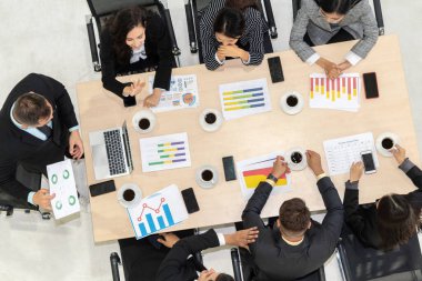 İş adamları grup toplantısı ofiste yukarıdan çekildi. İş kadınları, iş adamları ve ofis çalışanları, proje planlama belgeleriyle takım konferansında toplantı masasında çalışıyorlar. .