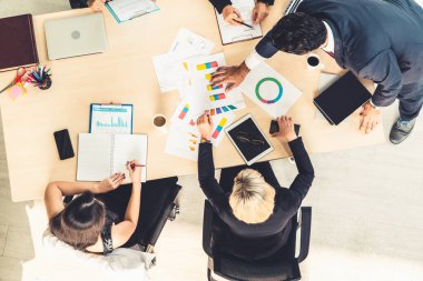 İş adamları grup toplantısı ofiste yukarıdan çekildi. İş kadınları, iş adamları ve ofis çalışanları, proje planlama belgeleriyle takım konferansında toplantı masasında çalışıyorlar. .