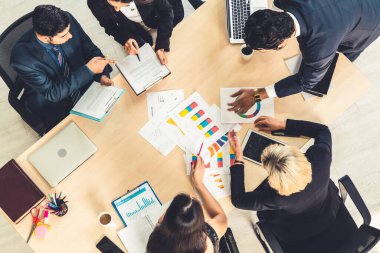 İş adamları grup toplantısı ofiste yukarıdan çekildi. İş kadınları, iş adamları ve ofis çalışanları, proje planlama belgeleriyle takım konferansında toplantı masasında çalışıyorlar. .