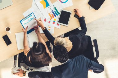 İş adamları grup toplantısı ofiste yukarıdan çekildi. İş kadınları, iş adamları ve ofis çalışanları, proje planlama belgeleriyle takım konferansında toplantı masasında çalışıyorlar. .