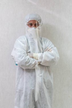 Koronavirüs ve Covid-19 enfeksiyonundan korunan hastane koğuşunda yüz maskesi ve yüz maskesi takan doktor. .