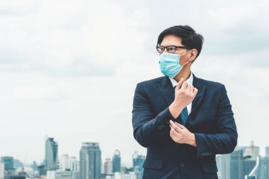 Coronavirus veya COVID-19 yüzünden yüz maskesi olan genç bir ofis çalışanı. Coronavirus veya COVID-19 'un yayılmasını engellemek ve işletmeyi yeniden açmak için koruyucu çalışma ortamı kavramı.