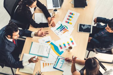 İş adamları grup toplantısı ofiste yukarıdan çekildi. İş kadınları, iş adamları ve ofis çalışanları, proje planlama belgeleriyle takım konferansında toplantı masasında çalışıyorlar. .