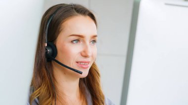 Ofiste çalışan kulaklık takan işadamları uzak müşteri ya da meslektaşlarını desteklemek için çalışıyorlar. Arama merkezi, tele pazarlama, müşteri destek acentesi telefon görüşmesinde hizmet sunar.