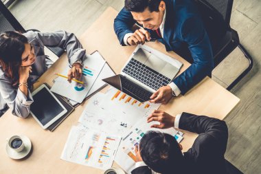 İş adamları grup toplantısı ofiste yukarıdan çekildi. İş kadınları, iş adamları ve ofis çalışanları, proje planlama belgeleriyle takım konferansında toplantı masasında çalışıyorlar. .