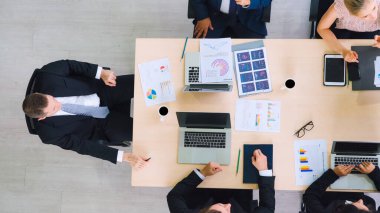 İş adamları grup toplantısı ofiste yukarıdan çekildi. İş kadınları, iş adamları ve ofis çalışanları, proje planlama belgeleriyle takım konferansında toplantı masasında çalışıyorlar. .