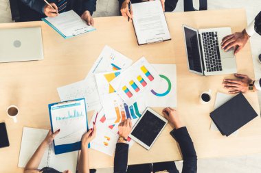 İş adamları grup toplantısı ofiste yukarıdan çekildi. İş kadınları, iş adamları ve ofis çalışanları, proje planlama belgeleriyle takım konferansında toplantı masasında çalışıyorlar. .