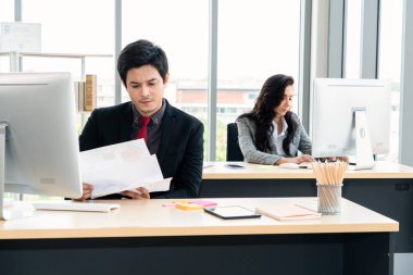 Modern ofis odasındaki masada çalışan iş adamları mali veri raporlarını incelerken .