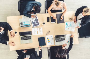 İş adamları grup toplantısı ofiste yukarıdan çekildi. İş kadınları, iş adamları ve ofis çalışanları, proje planlama belgeleriyle takım konferansında toplantı masasında çalışıyorlar. .