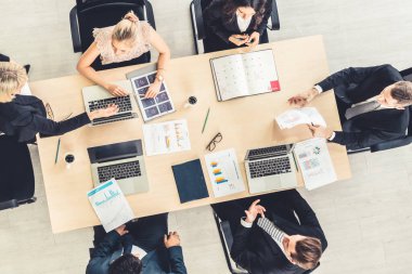 İş adamları grup toplantısı ofiste yukarıdan çekildi. İş kadınları, iş adamları ve ofis çalışanları, proje planlama belgeleriyle takım konferansında toplantı masasında çalışıyorlar. .