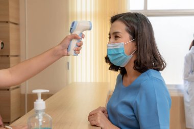 Ofiste ya da hastanede konuşurken resepsiyonist ve misafir maske takıyor. Covid 19 ve Coronavirus enfeksiyon koruması ve koruma politikası kavramı .