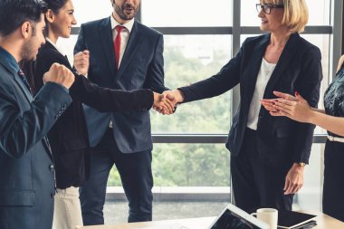 Şirket ofisinde iş adamlarının el sıkışması mali anlaşma konusunda profesyonel bir anlaşma gösteriyor.