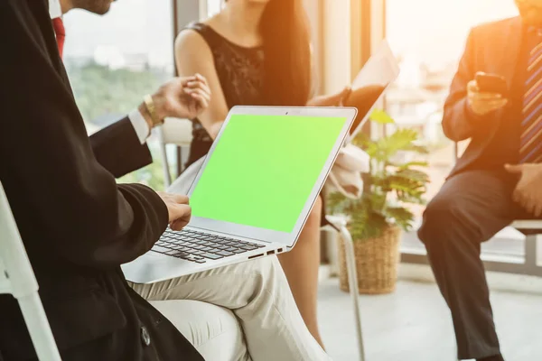 Business people in the conference room with green screen chroma key TV or computer on the office table. Diverse group of businessman and businesswoman in meeting on video conference call .