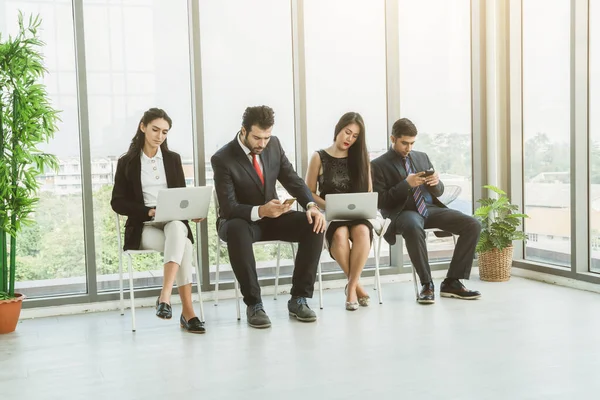 Job seekers and applicants waiting for interview on chairs in office. Job application and recruitment interview qualification concept.