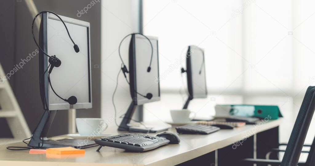 Call center computers and headsets all in office. Telemarketing, customer support agent provide service on telephone video conference call.
