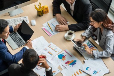 İş adamları grup toplantısı ofiste yukarıdan çekildi. İş kadınları, iş adamları ve ofis çalışanları, proje planlama belgeleriyle takım konferansında toplantı masasında çalışıyorlar. .
