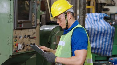 Fabrika atölyesinde makine kullanan akıllı bir fabrika işçisi. Endüstri ve mühendislik kavramı.