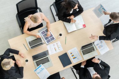 İş adamları grup toplantısı ofiste yukarıdan çekildi. İş kadınları, iş adamları ve ofis çalışanları, proje planlama belgeleriyle takım konferansında toplantı masasında çalışıyorlar. .