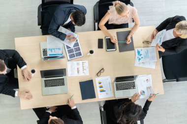 İş adamları grup toplantısı ofiste yukarıdan çekildi. İş kadınları, iş adamları ve ofis çalışanları, proje planlama belgeleriyle takım konferansında toplantı masasında çalışıyorlar. .