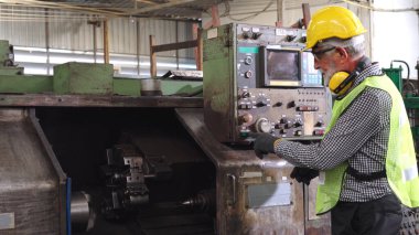 Fabrika atölyesinde makine kullanan akıllı bir fabrika işçisi. Endüstri ve mühendislik kavramı.