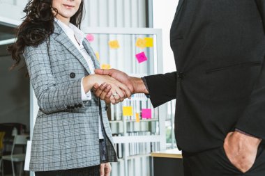 Şirket ofisinde iş adamlarının el sıkışması mali anlaşma konusunda profesyonel bir anlaşma gösteriyor.