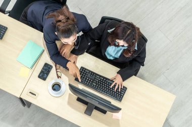 Ofiste üst kademeden kulaklık takan işadamları uzak müşteri ya da meslektaşlarını desteklemek için bilgisayarla çalışıyorlar. Çağrı merkezi, tele pazarlama acente servisi telefon ya da video konferans çağrısı.
