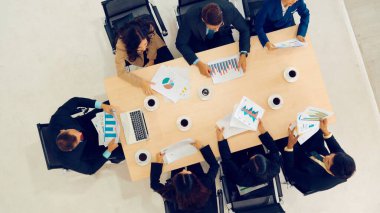 İş adamları grup toplantısı ofiste yukarıdan çekildi. İş kadınları, iş adamları ve ofis çalışanları, proje planlama belgeleriyle takım konferansında toplantı masasında çalışıyorlar. .