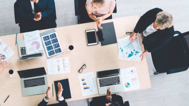 İş adamları grup toplantısı ofiste yukarıdan çekildi. İş kadınları, iş adamları ve ofis çalışanları, proje planlama belgeleriyle takım konferansında toplantı masasında çalışıyorlar. .
