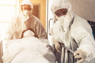 Acil servis doktoru ve doktor hastayı hastanedeki acil servise götürüyor. Doktor koronavirüs ve covid 19 koruma ve karantina kavramında koruyucu giysi ve yüz maskesi takıyor. .