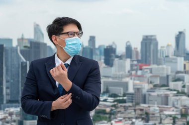 Coronavirus veya COVID-19 yüzünden yüz maskesi olan genç bir ofis çalışanı. Coronavirus veya COVID-19 'un yayılmasını engellemek ve işletmeyi yeniden açmak için koruyucu çalışma ortamı kavramı.