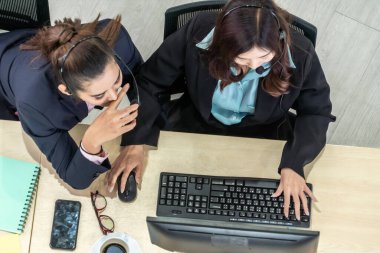Ofiste üst kademeden kulaklık takan işadamları uzak müşteri ya da meslektaşlarını desteklemek için bilgisayarla çalışıyorlar. Çağrı merkezi, tele pazarlama acente servisi telefon ya da video konferans çağrısı.