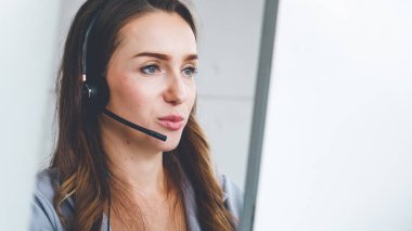 Ofiste çalışan kulaklık takan işadamları uzak müşteri ya da meslektaşlarını desteklemek için çalışıyorlar. Arama merkezi, tele pazarlama, müşteri destek acentesi telefon görüşmesinde hizmet sunar.