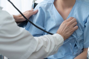 Profesyonel üniformalı doktor hastanedeki ya da klinikteki hastayı muayene ediyor. Sağlık, sağlık ve doktor hizmetleri konsepti.