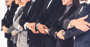 Başarılı iş adamları, işçi toplumunun güçlü ilişkilerini göstermek için bir arada duruyorlar. Modern ofiste güçlü bir takım çalışması sergileyen iş adamı ve iş kadınlarından oluşan bir ekip..