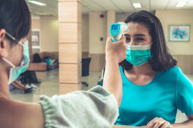 Ofiste ya da hastanede konuşurken resepsiyonist ve misafir maske takıyor. Covid 19 ve Coronavirus enfeksiyon koruması ve koruma politikası kavramı .