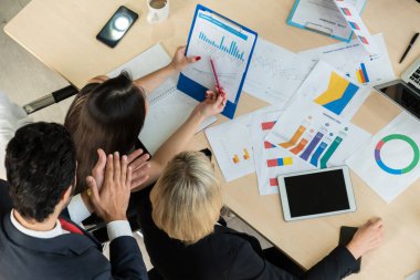İş adamları grup toplantısı ofiste yukarıdan çekildi. İş kadınları, iş adamları ve ofis çalışanları, proje planlama belgeleriyle takım konferansında toplantı masasında çalışıyorlar. .