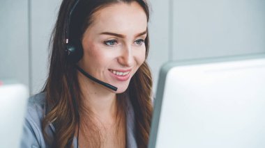 Ofiste çalışan kulaklık takan işadamları uzak müşteri ya da meslektaşlarını desteklemek için çalışıyorlar. Arama merkezi, tele pazarlama, müşteri destek acentesi telefon görüşmesinde hizmet sunar.