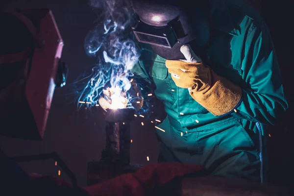 Metal welding steel works using electric arc welding machine to weld steel at factory. Metalwork manufacturing and construction maintenance service by manual skill labor concept.