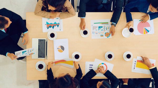 Business people group meeting shot from top view in office . Profession businesswomen, businessmen and office workers working in team conference with project planning document on meeting table .