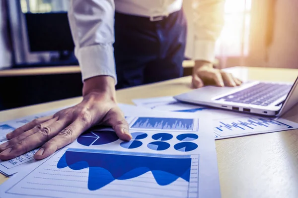 Businessman accountant or financial expert analyze business report graph and finance chart at corporate office. Concept of finance economy, banking business and stock market research.